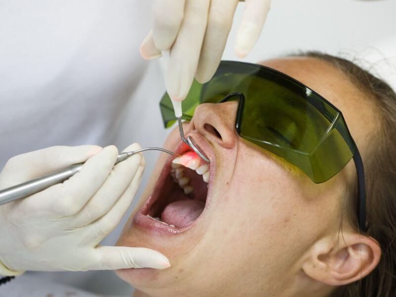 Dentist using a modern diode dental laser.