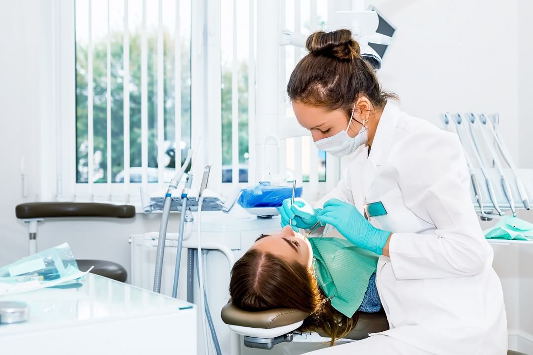 Female dentist checking up patient teeth with hypersalivation