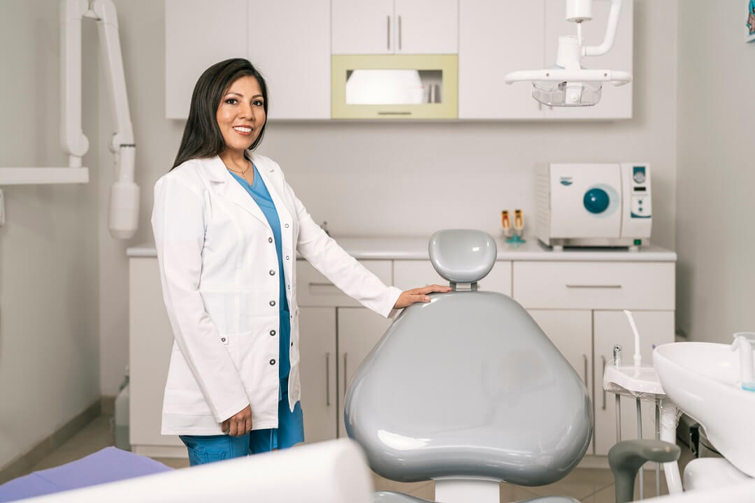 Dentist standing next to a dental chair in a dental clinic