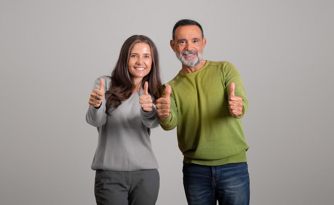 A couple giving a thumb up to a dentist they recommended 