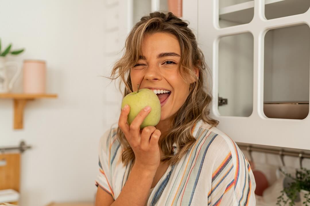 Woman eating a green apple
